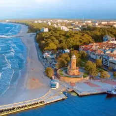Widok na nadmorskie miasteczko z latarnią morską, plażą i molo. Idealne miejsce, gdzie nad morze.
