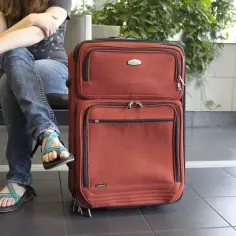 Osoba z paszportem i walizką czeka na lot. Czy Kenia jest bezpieczna na podróż?