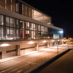 Nowoczesny terminal lotniska w nocy, z oświetlonymi oknami i pustymi drogami. Wygląda jak marbella lotnisko.