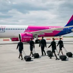 Załoga Wizz Air z walizkami idzie w stronę samolotu. Czyżby kolejny przypadek overbooking w Wizzair?