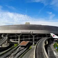 Charakterystyczny Terminal 1 na lotniskach w Paryżu, z krętymi drogami i skrzydłem samolotu.