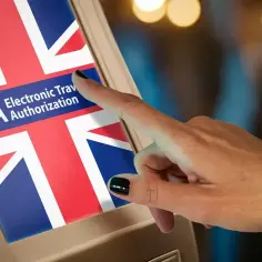 Palec dotyka ekranu z flagą Wielkiej Brytanii i napisem "ETA Electronic Travel Authorization". To krok do uzyskania wizy do Londynu.