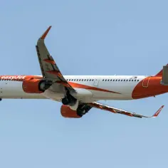 Samolot easyJet w locie, z widocznymi silnikami i skrzydłami. Idealny do podróży z bagażem podręcznym.