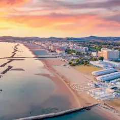 Zachód słońca nad Adriatykiem. Piękna plaża w Rimini, pełna leżaków i parasoli. Czy jest bezpiecznie? Tak, to popularny kurort.
