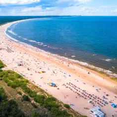 Szeroka, piaszczysta plaża z tłumem turystów, zielony las i błękitne morze – to jedne z najpiękniejszych plaż w Polsce.