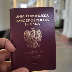 Dłoń trzyma polski paszport. Sprawdzam, ile ważny paszport, by zaplanować podróż.