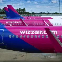 Różowe samoloty Wizzair stojące obok siebie. Może to być widok z lotniska, gdy planujesz wizzair zwrot biletu.