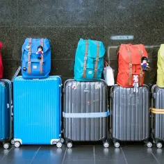 Różne walizki i plecaki czekają na podróż. Zastanawiasz się, ile kosztuje walizka w Wizzair?
