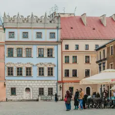 Kolorowe kamienice na rynku, ludzie spacerujący i siedzący w ogródku kawiarnianym. Idealne miejsce na city break, co to znaczy? Krótki, aktywny wypoczynek w mieście.