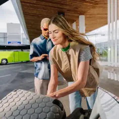 Para dostać się do Łazienek z Dworca Centralnego, można skorzystać z autobusu. Para pakuje bagaże do bagażnika, gotowa do podróży.