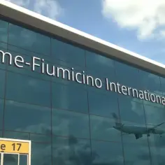 Szklana fasada lotniska Rome-Fiumicino International Airport, z odbijającym się samolotem i tabliczką "Gate 17".