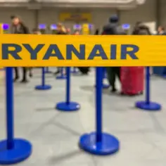 Kolejka do odprawy bagażu rejestrowanego Ryanair. Ludzie z walizkami czekają na swoją kolej.