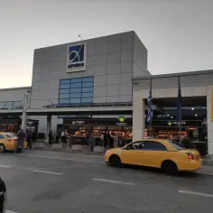 Żółte taksówki czekają na pasażerów przed budynkiem lotniska Ateny.