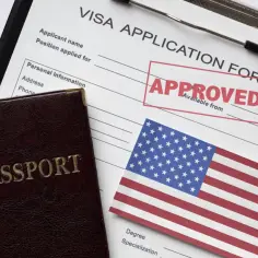 Paszport i formularz aplikacji o wizę do USA z pieczątką "APPROVED".