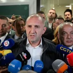 Mężczyzna przemawia do mediów, otoczony przez mikrofony. Pytanie "czy w Bułgarii jest bezpiecznie" nabiera tu szczególnego znaczenia.
