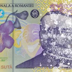 Fragment banknotu z rumuńską walutą, przedstawiający kwiat i twarz, rozpadający się w drobinki.