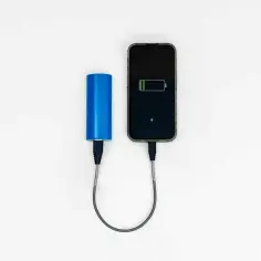 Niebieski powerbank Wizzair ładuje smartfon.