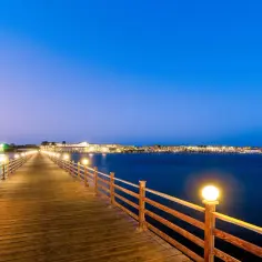 Drewniany molo oświetlone latarniami prowadzi do wybrzeża Marsa Alam. Woda jest spokojna, idealna do kąpieli, a temperatura wody w Marsa Alam jest zawsze przyjemna.