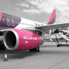 Samolot Wizz Air z pasażerami wchodzącymi po schodkach.
