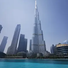 Burj Khalifa góruje nad nowoczesnym krajobrazem, gdzie jest Dubaj. Błękitna woda basenu odbija drapacze chmur.