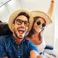 Para dowiedzieć się, ile się leci do Egiptu, wesoło pozuje do selfie w samolocie, ubrani w słomkowe kapelusze i okulary przeciwsłoneczne.
