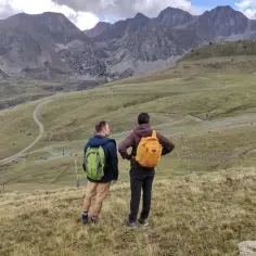 Dwóch turystów z plecakami podziwia krajobraz górski, zastanawiając się, gdzie leży Andora.