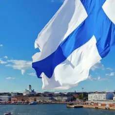 Flaga Finlandii powiewa nad Helsinkami. W Finlandii obowiązuje euro, więc to właśnie ta waluta jest używana.