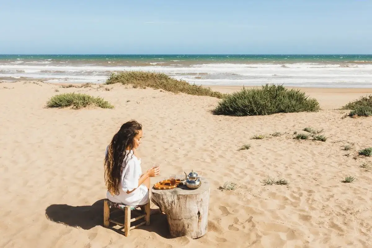 Kobieta pije herbatę na plaży, idealne miejsce, gdzie na wakacje do Tunezji.