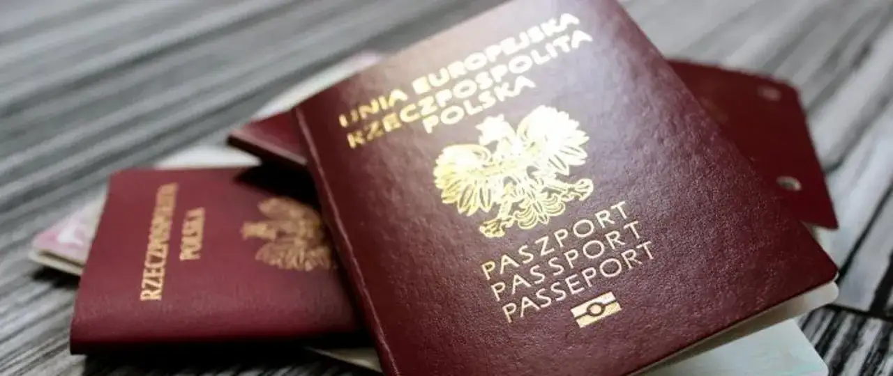 Polskie paszporty leżą na drewnianym blacie. Zastanawiasz się, ile trzeba czekać na paszport?