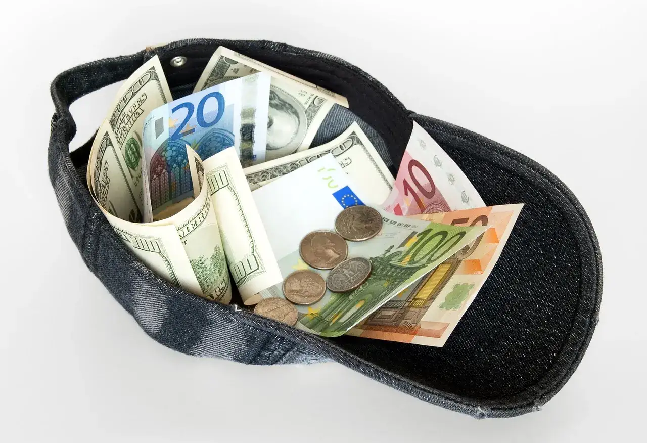 Czapka pełna dolarów i euro, idealna na wakacje w Turcji. Jaka waluta do Turcji na wakacje? Tu masz wybór!