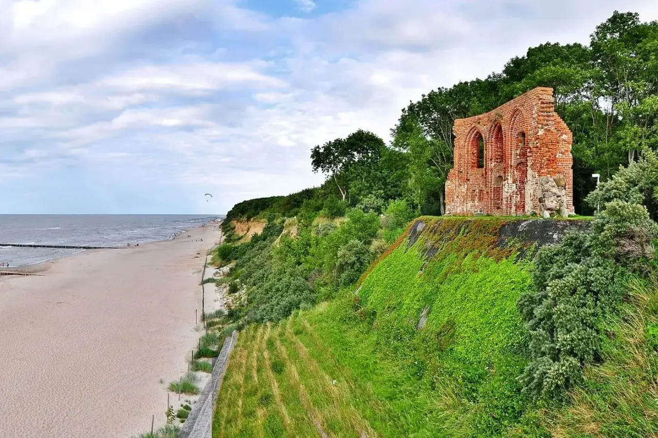Ruiny zamku na klifie nad piaszczystą plażą, jedna z najpiękniejszych plaż w Polsce.