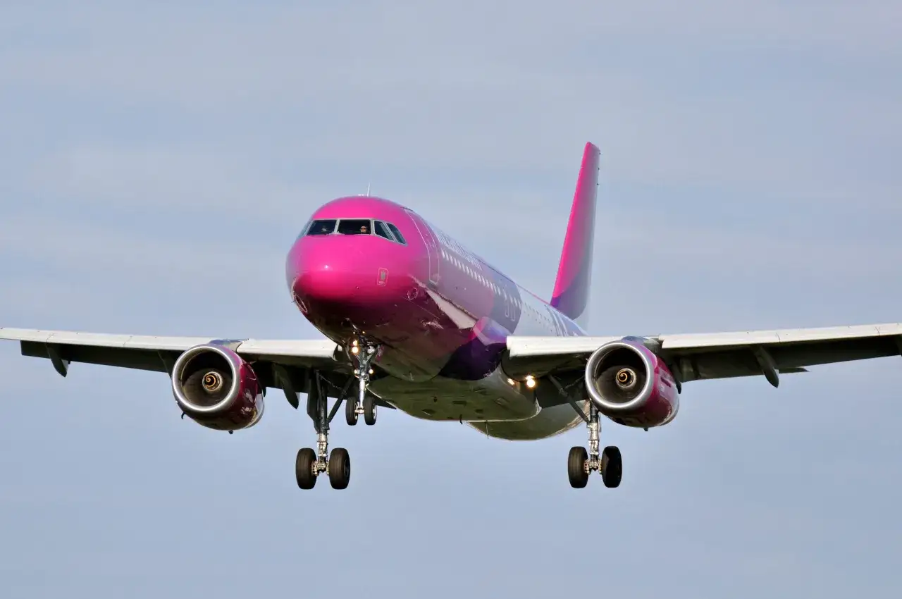 Różowy samolot Wizzair zbliża się do lądowania. Miejmy nadzieję, że nie będzie opóźniony lot, odszkodowanie Wizzair to ostatnia rzecz, której potrzebujemy.