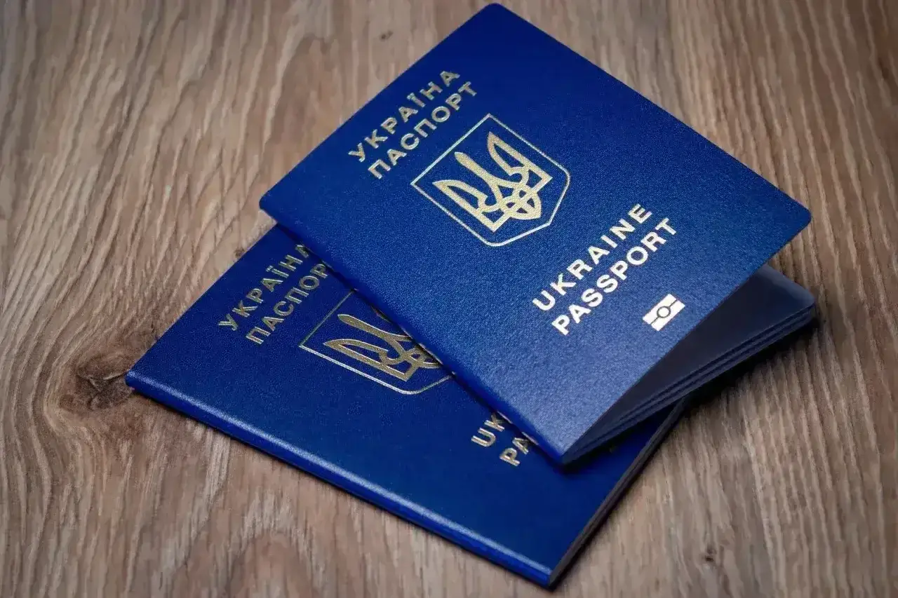 Dwa niebieskie paszporty Ukrainy leżą na drewnianym stole. Planujesz wyjazd do Turcji? Paszport czy dowód?