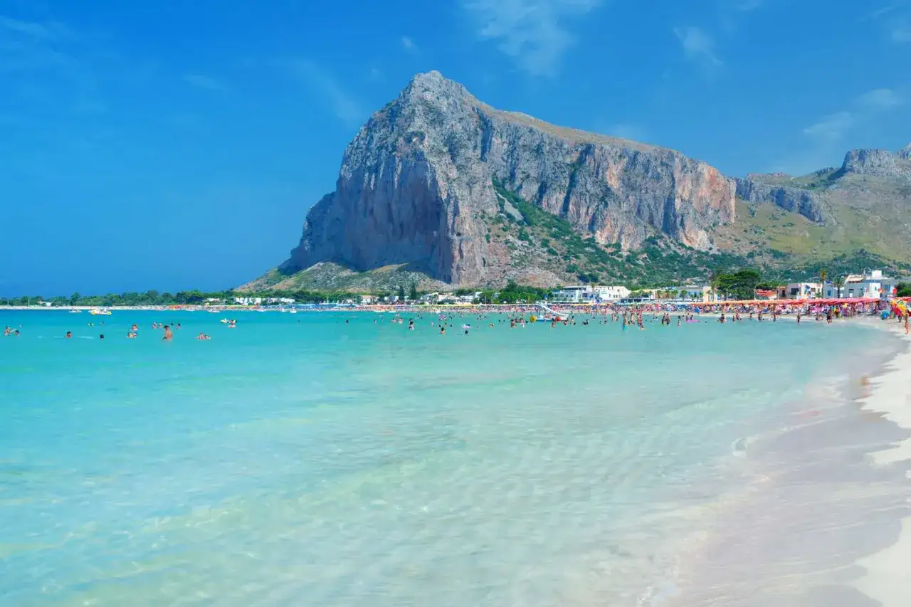 Plaża San Vito Lo Capo, jedna z najpiękniejszych plaż Sycylii, z turkusową wodą i majestatyczną górą Monte Monaco w tle.