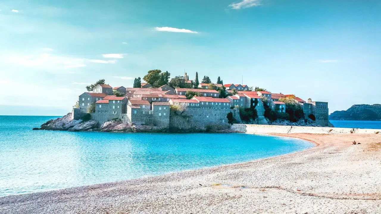 Wyspa Sveti Stefan, jedna z głównych atrakcji Czarnogóry, z kamiennymi domami i czerwonymi dachami, otoczona turkusowym morzem.
