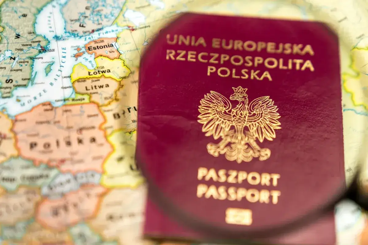 Polski paszport na tle mapy Europy. Planujesz podróż do Londynu? Ten dokument to klucz do zwiedzania.