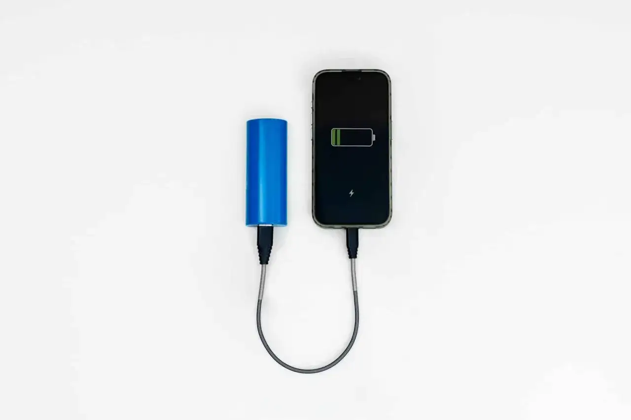 Niebieski powerbank Ryanair ładuje telefon.